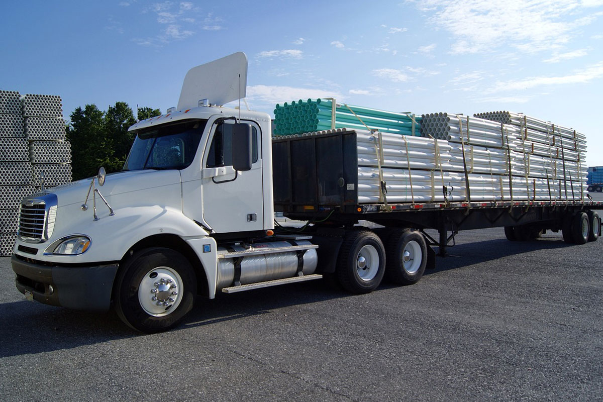 Flatbed truck carrying PVC pipes